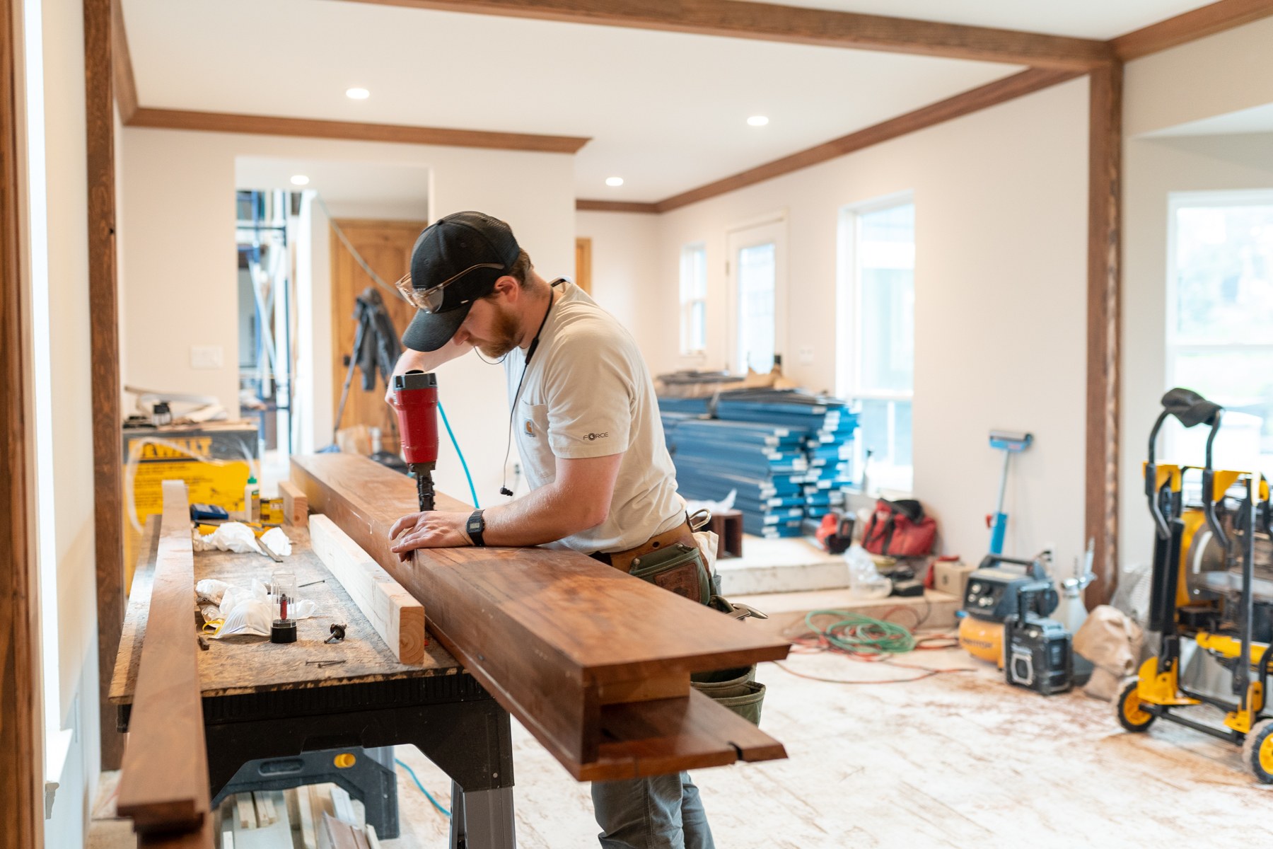 Ryan working with a nail gun on a wood beam — craftsmanship in action
